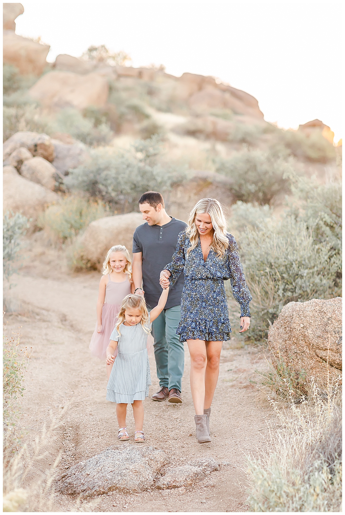 Family holding hands walking desert trail in Scottsdale, AZ photographed by Christine Deaton Creative