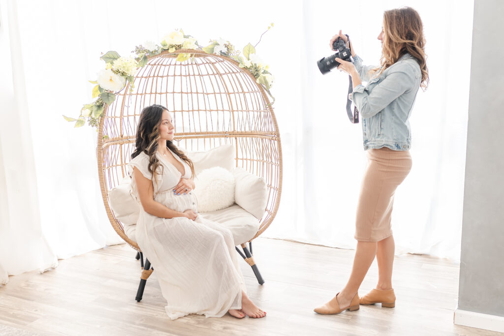 Christine Deaton photographing a maternity client in studio with her canon mark iii camera for lifestyle photography.