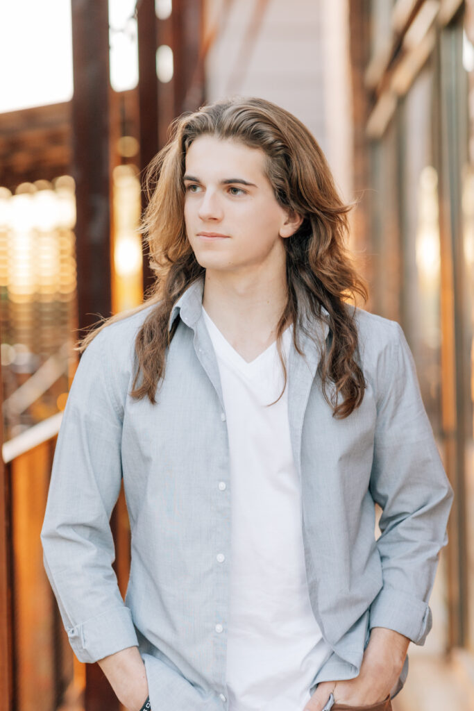 Cave Creek high School senior in white t-shirt, and gray button up shirt looking to the left with a soft smile. 