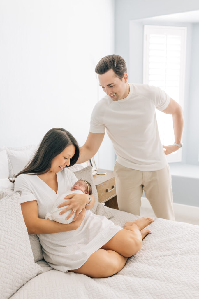 Emotive family portrait from Nest: A Luxury Maternity & Newborn Workshop, where mom and dad share a quiet embrace with their new baby.