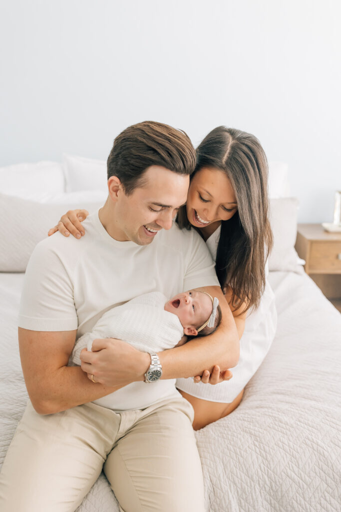 New parents holding their newborn close during Nest: A Luxury Maternity & Newborn Workshop, captured in a soft, storytelling moment full of love.