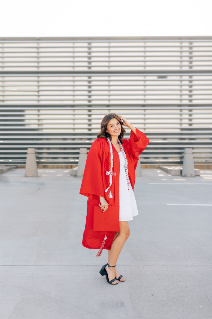 What to wear for senior pictures for girls – Phoenix senior wearing a white dress and black heels and red cap and gown for urban senior photos
