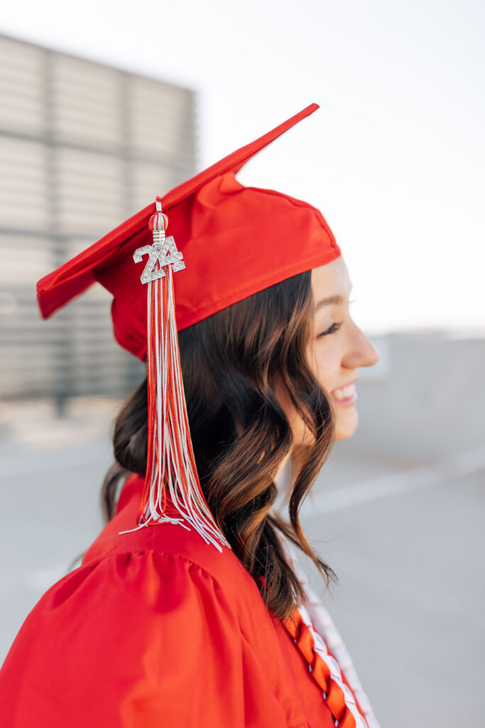 What to wear for senior pictures for girls – Phoenix senior wearing a white dress and black heels and red cap and gown for urban senior photos