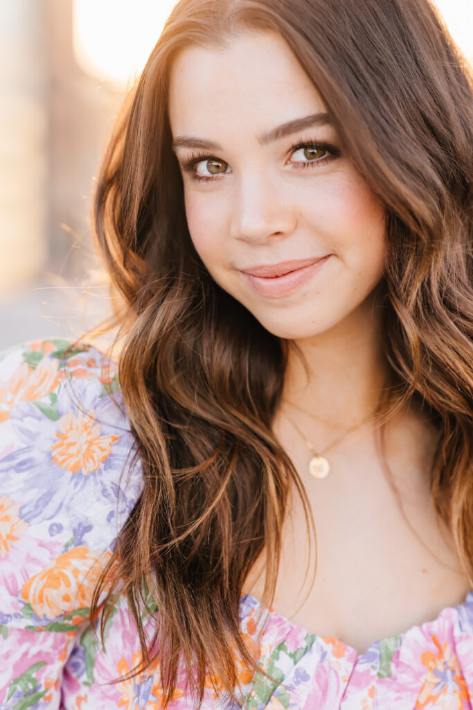 What to wear for senior pictures for girls – Scottsdale senior wearing a pastel floral mini dress and delicate gold necklace for downtown senior photos